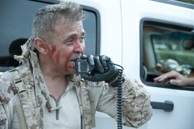 An actor speaks frantically into a radio near the starting line Saturday, June 28, 2014 before the post-apocalypse themed 5k race "Escape from Baton Rouge" near the Capitol building downtown.