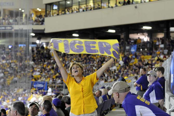 A fan cheers while holding up a sign Sunday, April 1, 2014 during the Tigers' 5-4 loss against Houston in Alex Box Stadium.