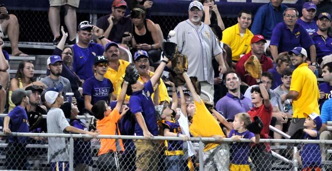 Fans reach up to catch the ball Monday, April 2, 2014 during the Tigers' 12-2 loss against Houston in Alex Box Stadium.