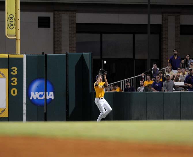 LSU sophomore outfielder Mark Laird (9) reaches up to catch the ball Monday, April 2, 2014 during the Tigers' 12-2 loss against Houston in Alex Box Stadium.