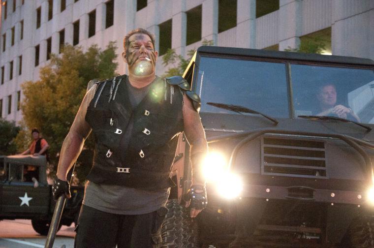 An actor attempts to intimidate race participants Saturday, June 28, 2014 during the post-apocalypse themed 5k race "Escape from Baton Rouge" near the Capitol building downtown.