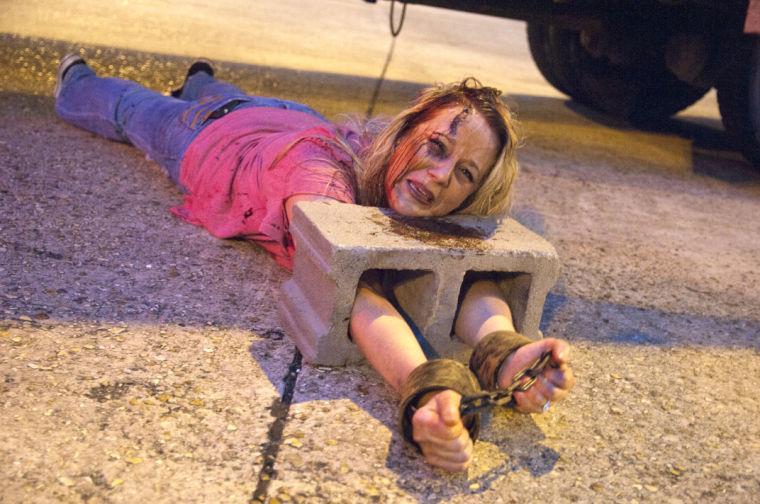 An actor attempts to intimidate race participants Saturday, June 28, 2014 during the post-apocalypse themed 5k race "Escape from Baton Rouge" near the Capitol building downtown.