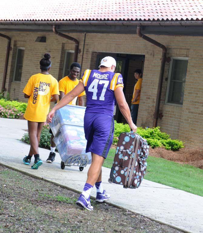 LSU freshman tight end John David Moore (47) assists carrying luggage on move-in day August 20, 2014 outside the Pentagon.