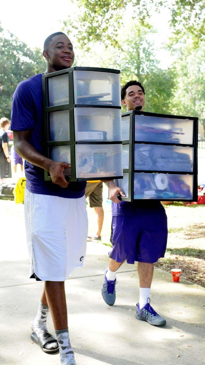 LSU basketball players Jarell Martin (left) and Josh Gray (right) carry a student's belongings for move in day at the Pentagon.