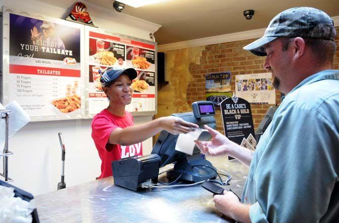 Cane's server Lakinyta Walken (left) rings up customer Joey Lemoine (right) for his meal.