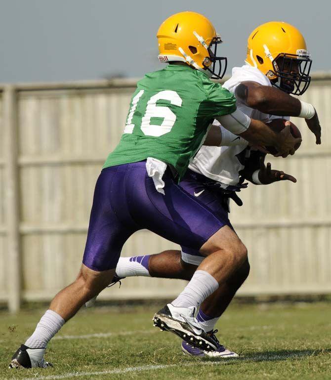 LSU junior quarterback Brad Kragthorpe (16) hands the ball to senior running back Kenny Hilliard (27) Tuesday, August 5, 2014 during Fall Camp in the Charles McClendon Practice Facility.