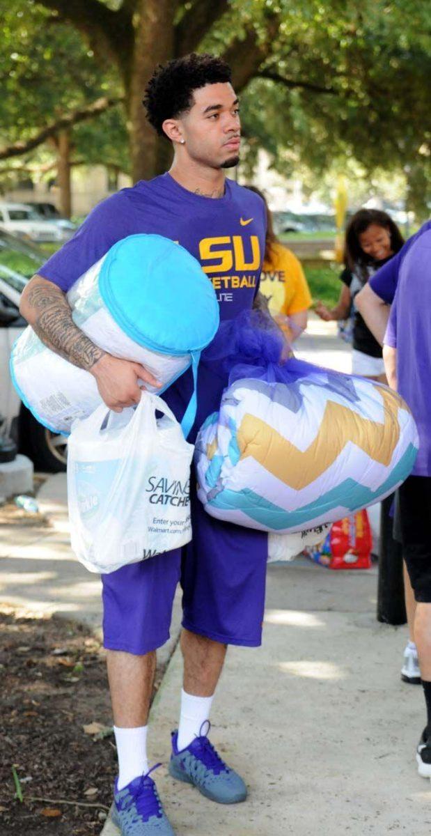 LSU basketball player Josh Gray assists a student during move in day Wednesday August 20, 2014 at the Pentagon.