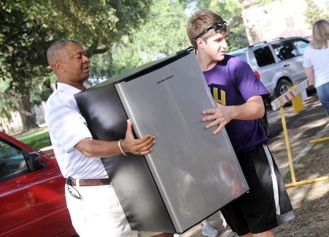 LSU basketball head coach Johnny Jones (left) assists a student with moving a mini fridge Wednesday, August 20, 2014 outside of the Pentagon.