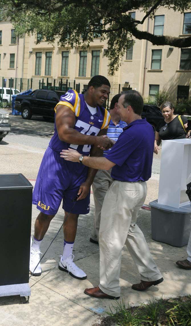 LSU senior offensive tackle La'el Collins (70) greets LSU President F. King Alexander on move-in day Wednseday August 20, 2014 outside West Hall.