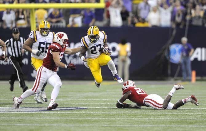 LSU senior running back Kenny Hilliard (27) vaults over a fallen opponent Saturday, August 30, 2014 during the Tigers' 28-24 victory against Wisconsin in the 2014 Advocare Texas Kickoff, held in the NRG Stadium in Houston, Texas.