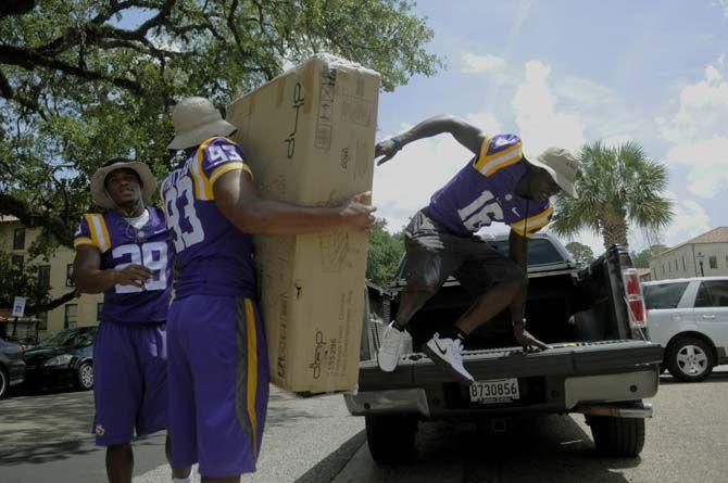 LSU sophomore saftey Rickey Jefferson (29), freshmen defensive end M.J. Patterson (93) and sophomore defensive back Tre'Davious White (16) assist students move into their dorms Wednseday August 20, 2014 in West Hall.