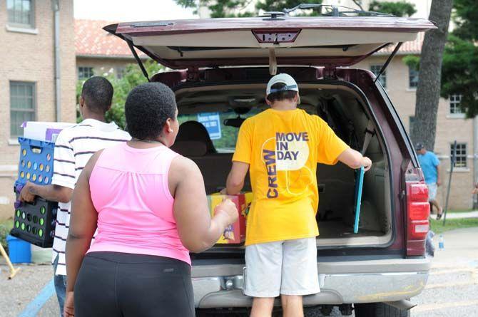 Student helps new resident move in on August 20, 2014.