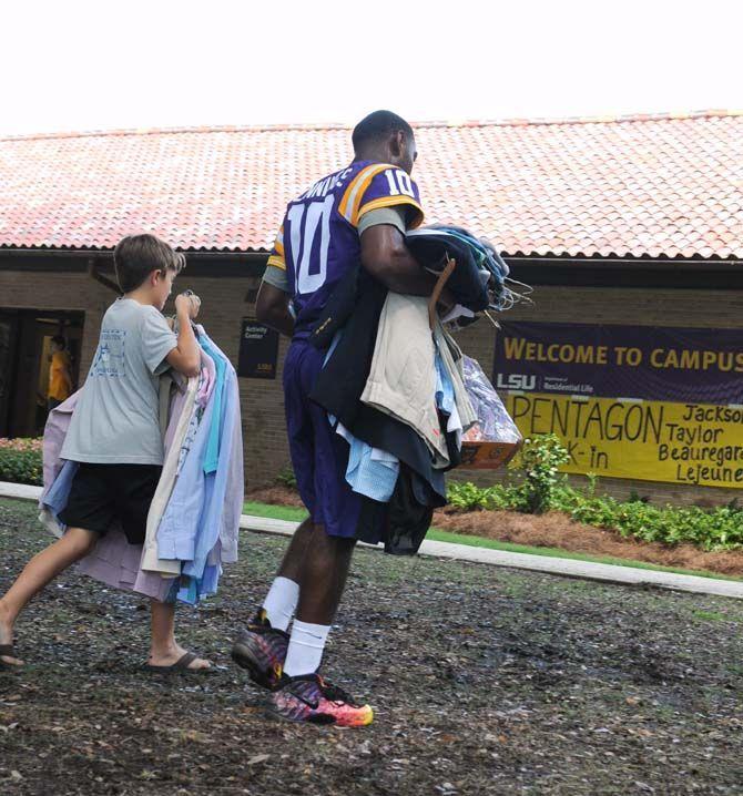 LSU sophomore quarterback Anthony Jennings (10) helps families move in-coming students into their dorms at the Pentagon on August 20, 2014.