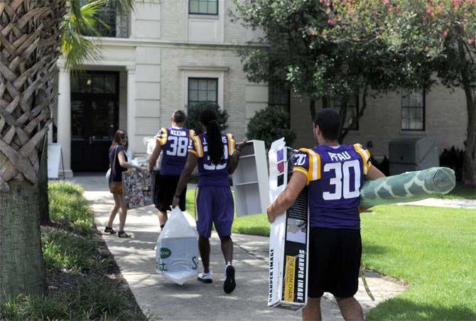 LSU junior punter Jamie Keehn (38), junior cornerback Jalen Collins (32) and freshman placekicker Kyle Pfau (30) assist students move into their dorms Wednseday August 20, 2014 outside West Hall.