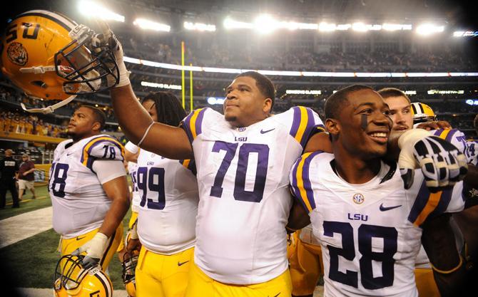 LSU junior offensive tackle La'el Collins (70) raises his helmet in the air Aug. 31, 2013 after the 37-27 victory against TCU in the Cowboys Classic at AT&amp;T Stadium in Arlington Field.