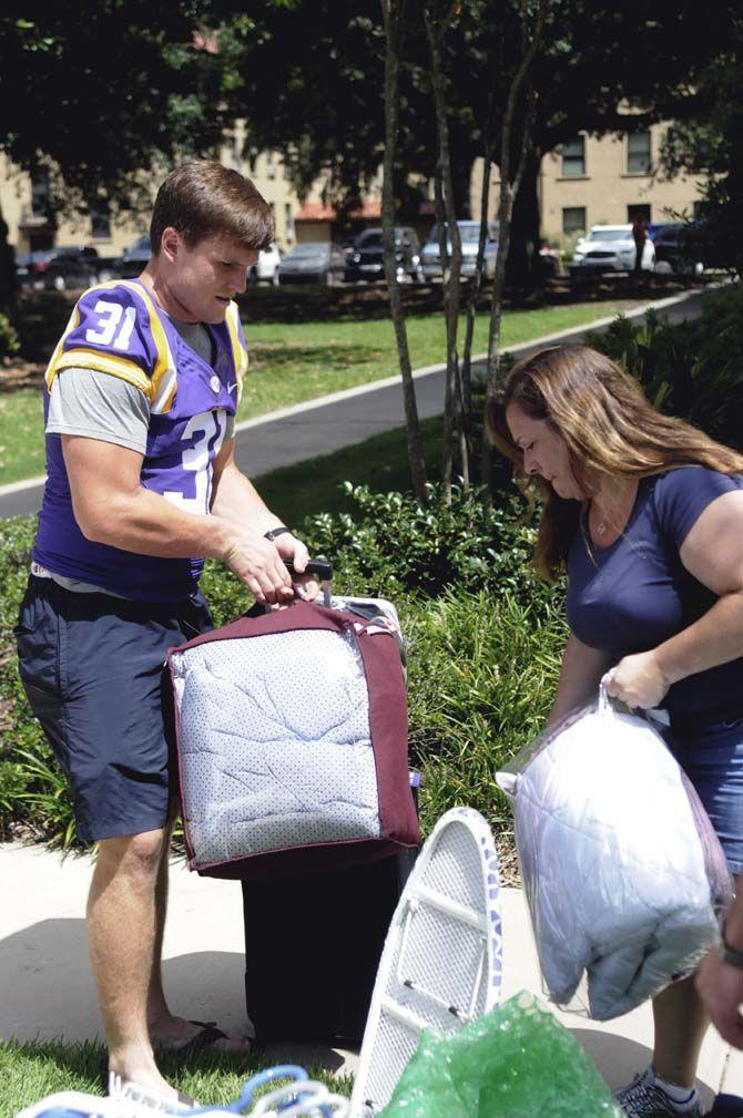 LSU senior linebacker D.J. Welter (31) assist students move into their dorms Wednseday August 20, 2014 outside West Hall.