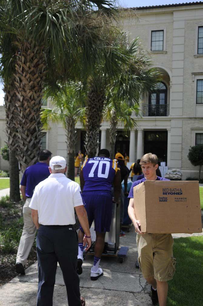 LSU senior offensive tackle La'el Collins (70) and LSU President F. King Alexander assist students moving into their dorms Wednseday August 20, 2014 outside West Hall.