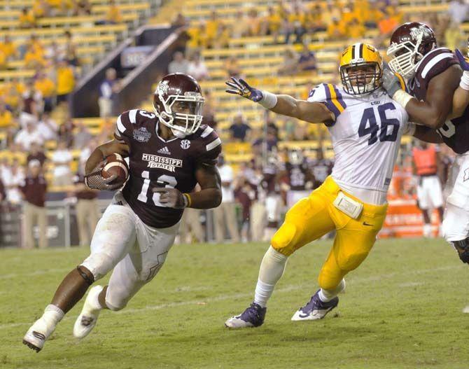 LSU sophmore defensive end Tashawn Bower is restrained from tackling a Mississippi State player during the game Saturday September 20, 2014 where LSU lost 34-29 in Tiger Stadium.