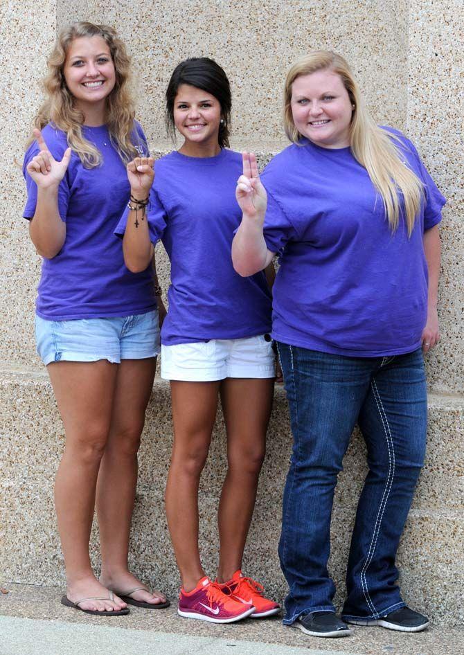 LSU early childhood education junior Lindsey Baker (left), communication disorder senior Lauren Ortego (middle), and communication studies senior Sam Sherwood sign the letters "LSU (read left to right)."