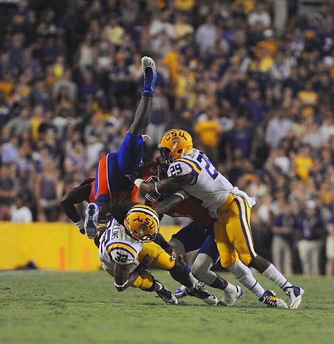 LSU junior cornerback Jalen Collins (32) and sophomore safety Rickey Jefferson (29) tackle Sam Houston State sophomore quarterback Jared Johnson Saturday, September 6, 2014 during the Tigers' 56-0 win against the Bearkats in Tiger Stadium.