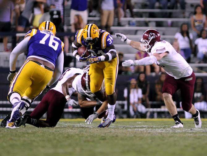 LSU freshman running back Darrel Williams dodges a tackle from multiple NMSU players Saturday, September 27, 2014 during the Tigers' 63-7 victory against the Aggies in Tiger Stadium.