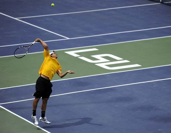 LSU sophomore Tam Trinh begins his serve Sunday, March 30, 2014 during the Men's Tennis doubles match against Florida at W.T. "Dub" Robinson Stadium.