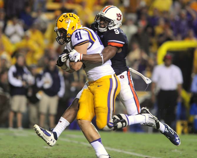 LSU junior tight end Travis Dickson (41) attempts to ward off Auburn junior defensive back Jermaine Whitehead (9) on Saturday, September 21, 2013, during the Tigers' 35-21 victory against Auburn in Tiger Stadium.