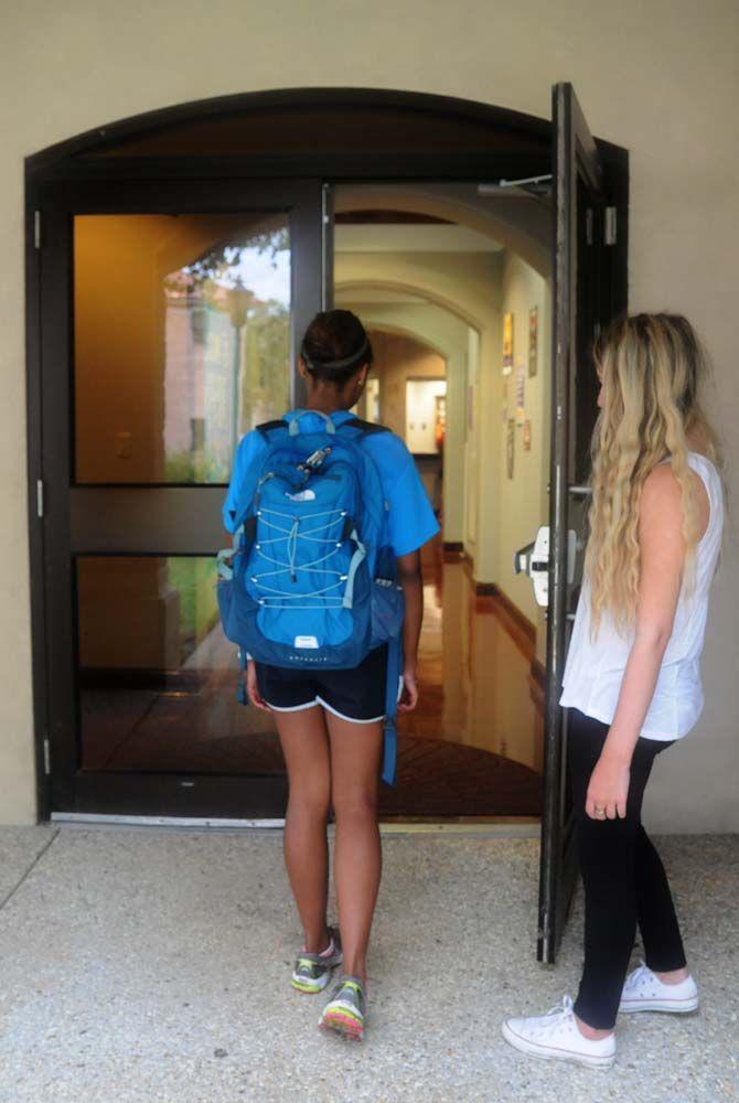 LSU student assisting another student by opening the door outside East Campus Apartments Activity Center Tuesday September 2, 2014.