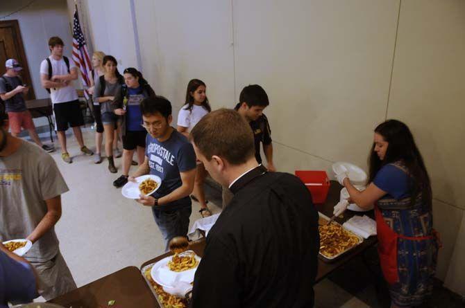 Students enjoy their free lunch probided by Our Lady of Mercy Catholic Church Thursday, September 4, 2014 in Christ the King Catholic Church.