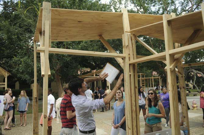 LSU undergraduate architecture proffesor Jeff Carney evaluates student built structures Monday, September 8, 2014 in the quad.