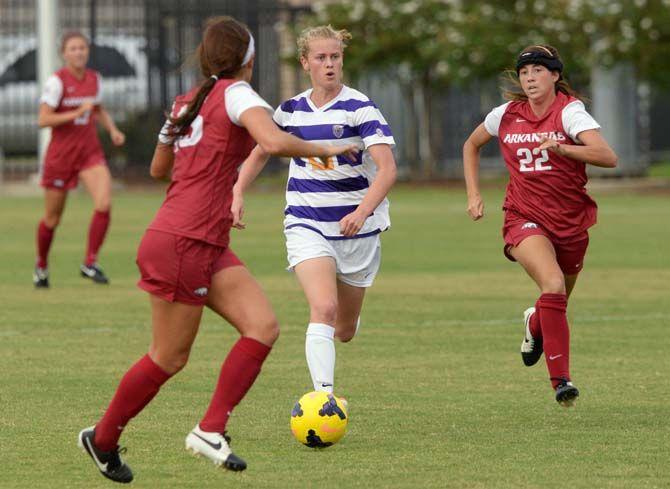 LSU sophomore defender Megan Lee (13) runs to pass two deffenders and score a goal Sunday, September 28, 2014 at LSU soccer stadium where LSU tied to Arkansas 3-3.