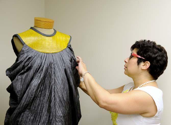 Lisa McRoberts, assistant professor in the textiles, apparel design and merchandising program, fixes clothing made for the alligator project.