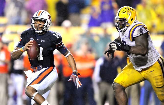 LSU junior defensive tackle Ego Ferguson (9) pursues Auburn junior quarterback Nick Marshall (14) Saturday, Sept. 21, 2013 during the Tigers' 35-21 victory against Auburn in Tiger Stadium.