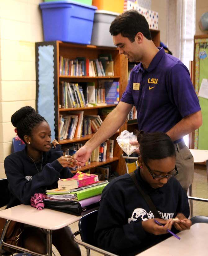 Student body President Clay Tufts hands out LSU student government pins to students at Sherwood Middle Academic Magnet School Friday September 19, 2014.