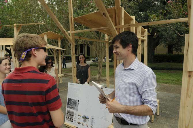 LSU undergraduate architecture proffesor Jeff Carney evaluates student built structures Monday, September 8, 2014 in the quad.