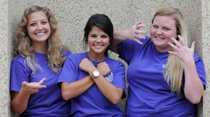 LSU early childhood education junior Lindsey Baker (left), communication disorder senior Lauren Ortego (middle), and communication studies senior Sam Sherwood sign "we love tigers (read left to right)."