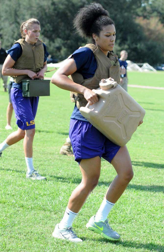 LSU women's basketball junior guard Anne Pedersen (left) and junior guard Daniellie Ballard (right) carry supplies for a practice run by marines Friday September 19, 2014.