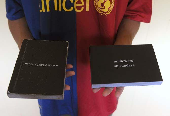 Photography senior Patrick Melon holds his photo books Friday September 5, 2014.