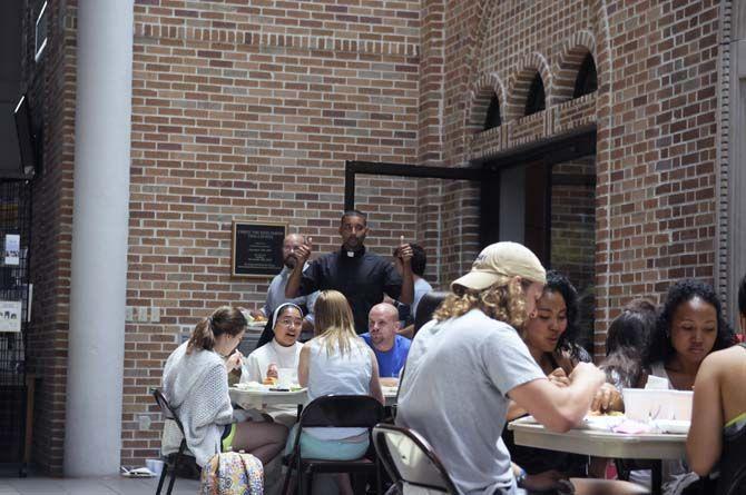 Students enjoy their free lunch probided by Our Lady of Mercy Catholic Church Thursday, September 4, 2014 in Christ the King Catholic Church.