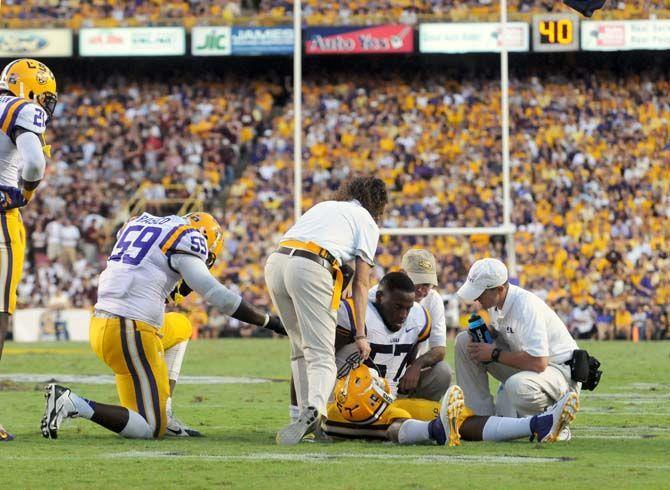 LSU senior defensive end Jermauria Rasco kneels for teammate Devon Godchaux during a small injury in Tiger Stadium Saturday, September 20, 2014.