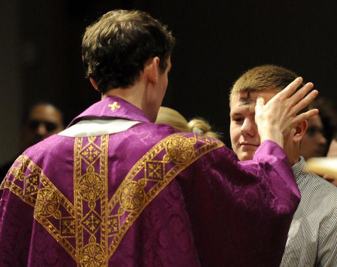 Fr. Matthew McCaughey distributes ashes Feb. 13, 2013 to a parishioner on Ash Wednesday at Christ the King Parish and Catholic Center at LSU.