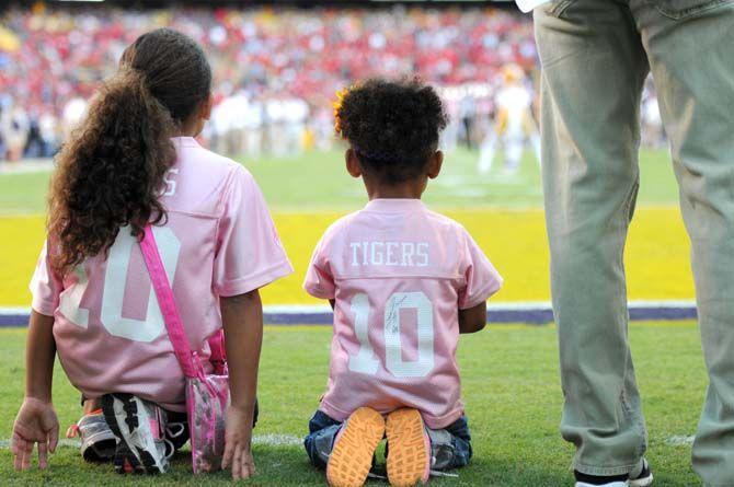 Two young girls sit at the endzone in Tiger Stadium to watch the Tigers warm up before the Homecoming game against Ole Miss Saturday, October 25, 2014.