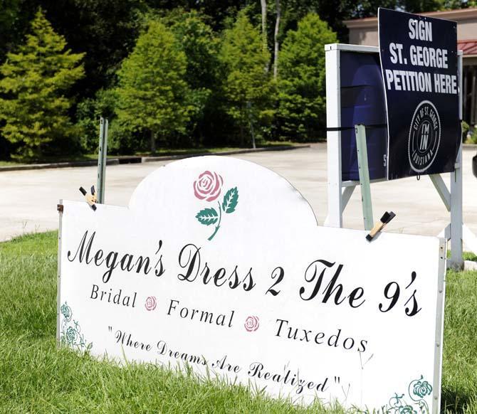 A sign encouraging citizens to sign a petition instituting the area of St. George as a city are arranged outside of Megan's Dress 2 the 9's Wednesday, June 18, 2014.