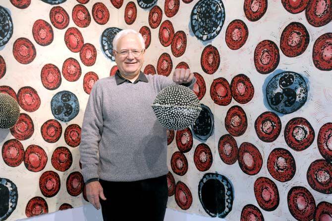 Dr. Eric Avery stands with his piece "Condom filled Pi&#241;ata" and wallpaper installation "Tatoo." Avery's exhibit HIV/AIDS: Witness, Healer, Survivor will be at LSU's Glassel Gallery October 28 - December 7, 2014.