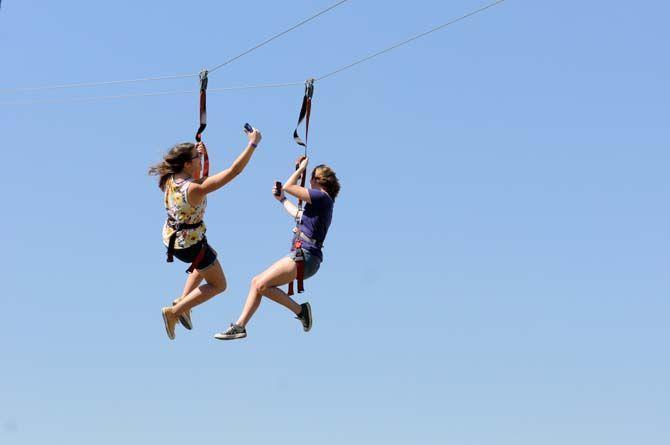 Two women take selfies down a zipline on the Parade Grounds Saturday, October 25, 2014 before the LSU game against Ole Miss.