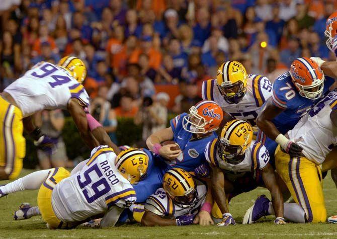 Florida junior quaterback Jeff Driskel (6) is tackled by LSU players Saturday, October 11, 2014 during the Tigers' 30-27 victory in Ben Hill Griffin Stadium.