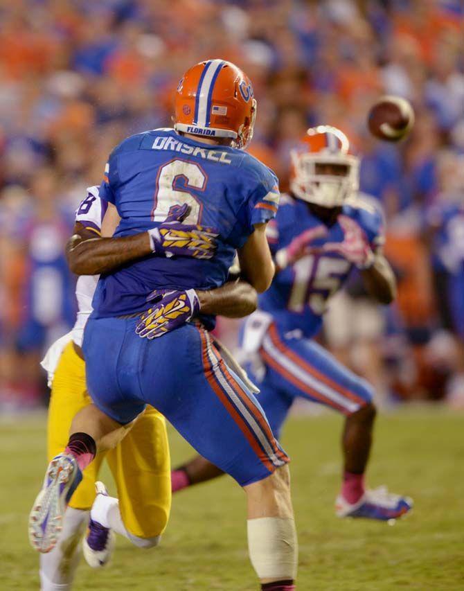 Florida junior quaterback Jeff Driskel (6) is tackled by LSU junior defensive back Jalen Mills (28) shortly after releasing a pass Saturday, October 11, 2014 during the Tigers' 30-27 victory in Ben Hill Griffin Stadium.