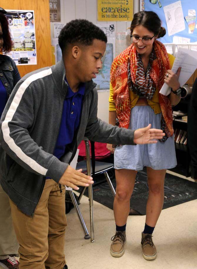 English secondary education senior Gabrielle Swindle watches high school junior Jalon Jones perform the robot in the break dancing corner during a group exercise Wednesday October 22, 2014 at McKinley high school.