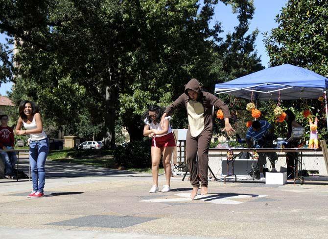 (Left to right) Bianca Dixon, Elizabeth Borda, and Jose Lloveras-Fuentes, members of the HSCS, participate in a flash mob Tuesday at Free Speech Plaza.