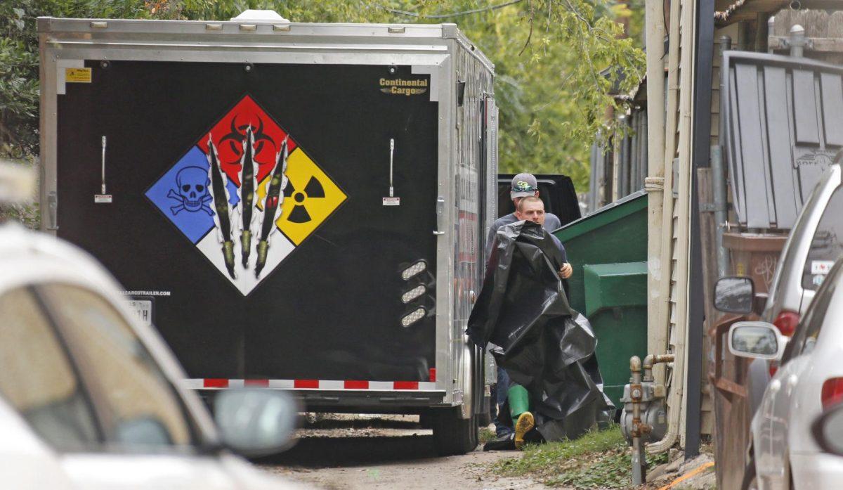 CG Environmental-Cleaning Guys hazmat team members puts up a tarp to shield the view in the alley near the residence of the Dallas woman who's the first known person to have contracted Ebola in the U.S., Sunday, Oct. 12, 2014. (AP Photo/The Dallas Morning News, Louis DeLuca) MANDATORY CREDIT; MAGS OUT; TV OUT; INTERNET USE BY AP MEMBERS ONLY; NO SALES